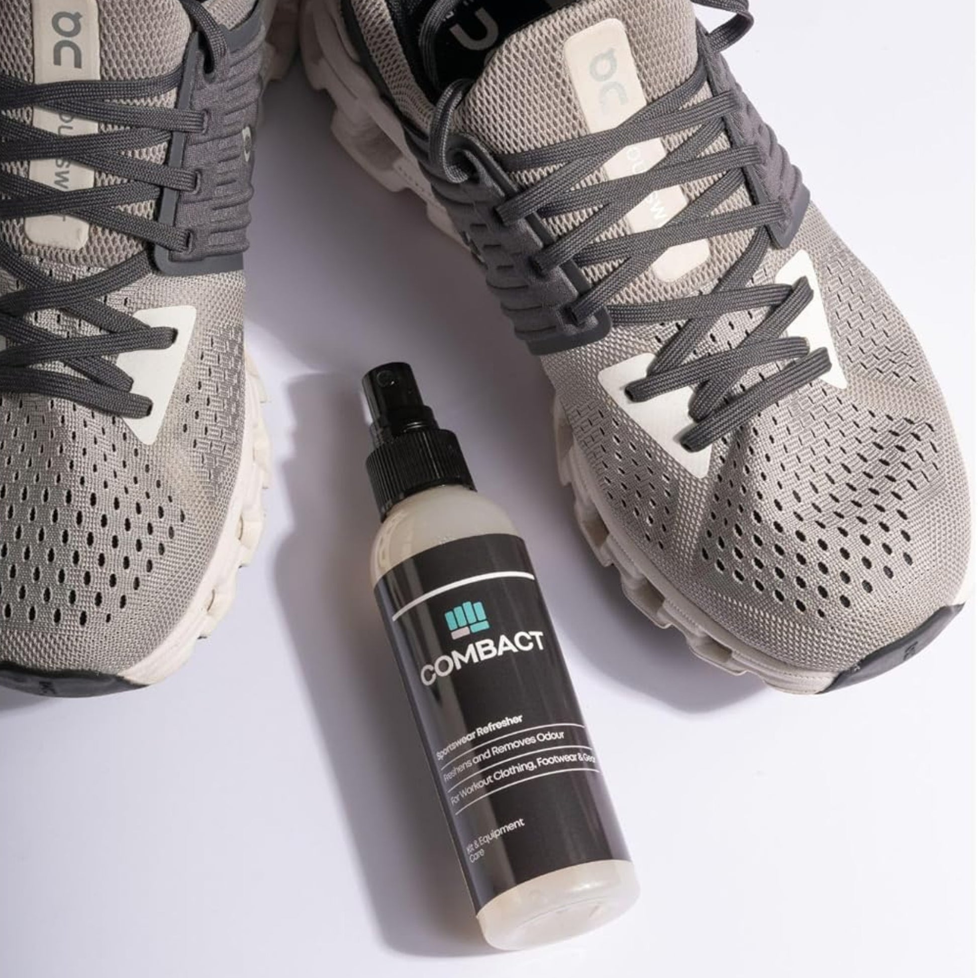 Photograph of a pair of running trainers and a deodoriser spray, the Sportswear Refresher by Combact. Used as a Running Trainer Odour Remover and a Running Trainer Deodorizer